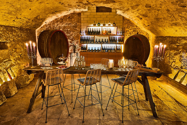 Sommelier führt Gäste durch die Weinprobe im historischen Gewölbekeller