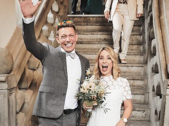 Strahlendes Hochzeitspaar auf historischer Freitreppe – Weinforum Franken als Hochzeits-Eventlocation in Eibelstadt