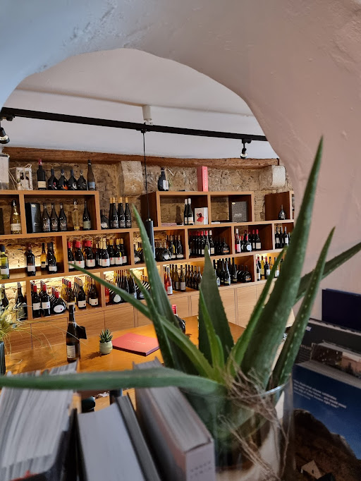 Blick durch den Gewölbebogen auf das Weinregal der Vinothek mit über 120 Weinen